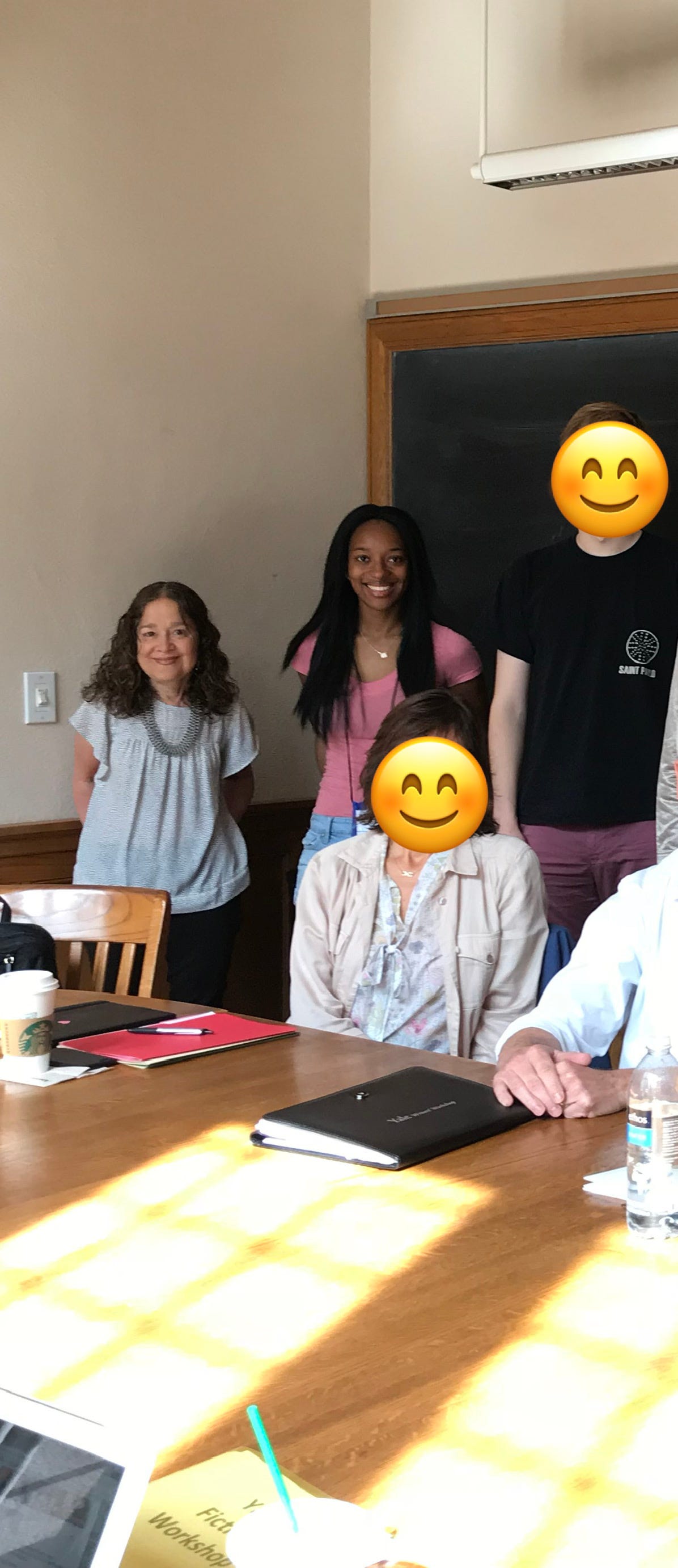 A photo of Kat Lewis and Marian Thurm standing in a Yale classroom with Kat’s classmates.
