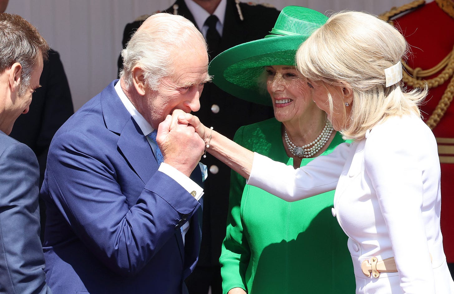 King Charles kissing the hand of Brigitte Macron