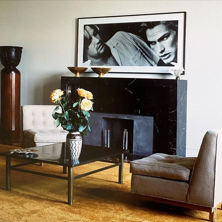 This may contain: a living room filled with furniture and a painting on the wall above a fire place
