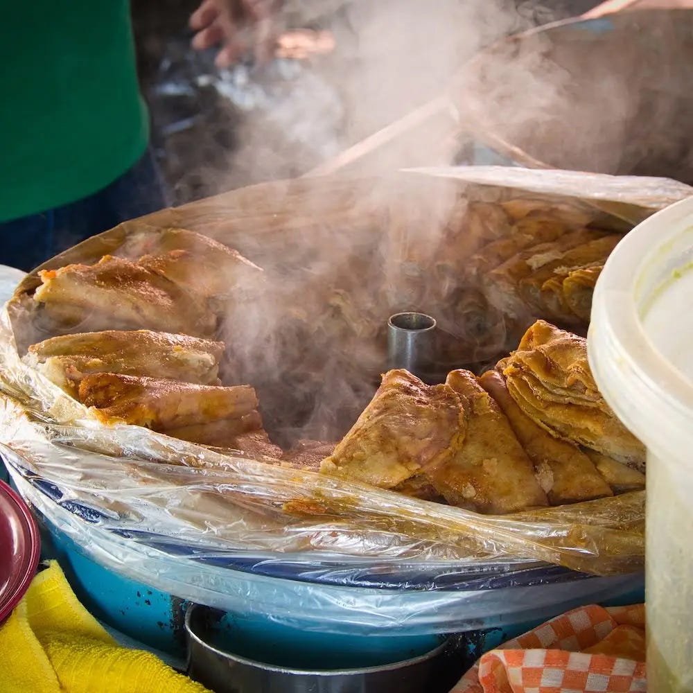 A steaming pan of folded tortillas