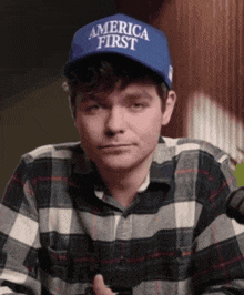 a man wearing a plaid shirt and a hat that says america first
