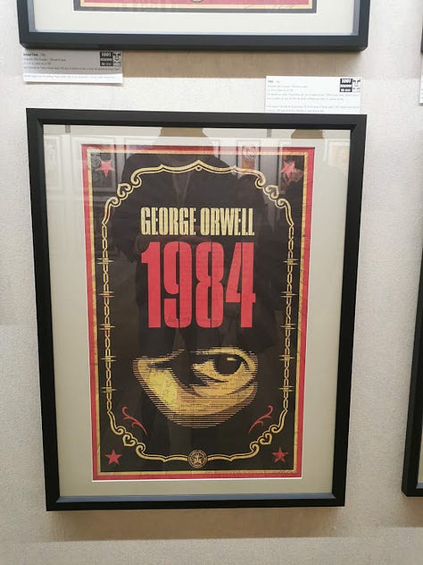 Photos of Shepard Fairey silkscreen prints in a large exhibition hall