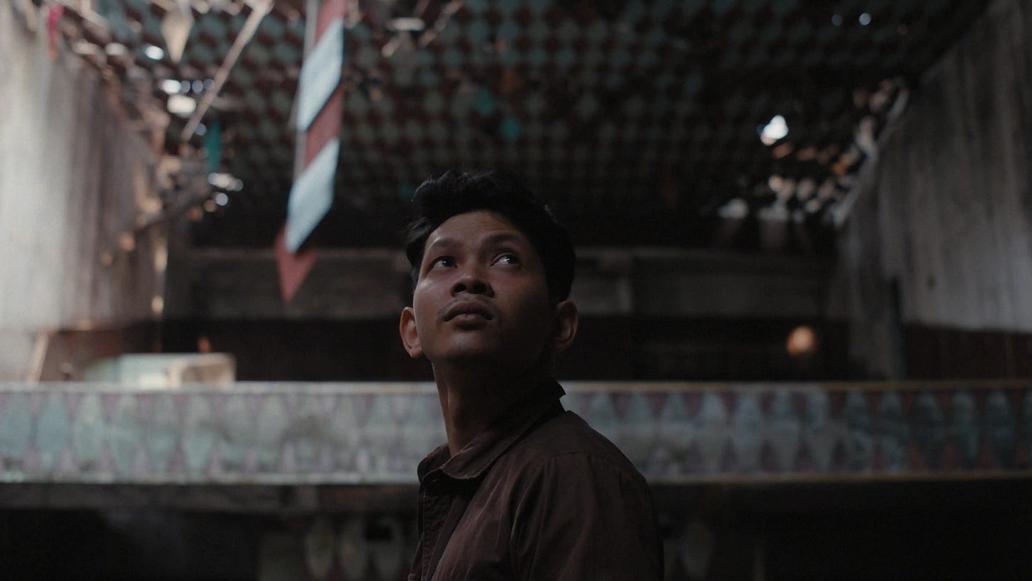 Scene from the film Becoming Human showing Thida, a spirit guardian, inside an abandoned cinema in Battambang, symbolizing memory, loss, and rebirth.