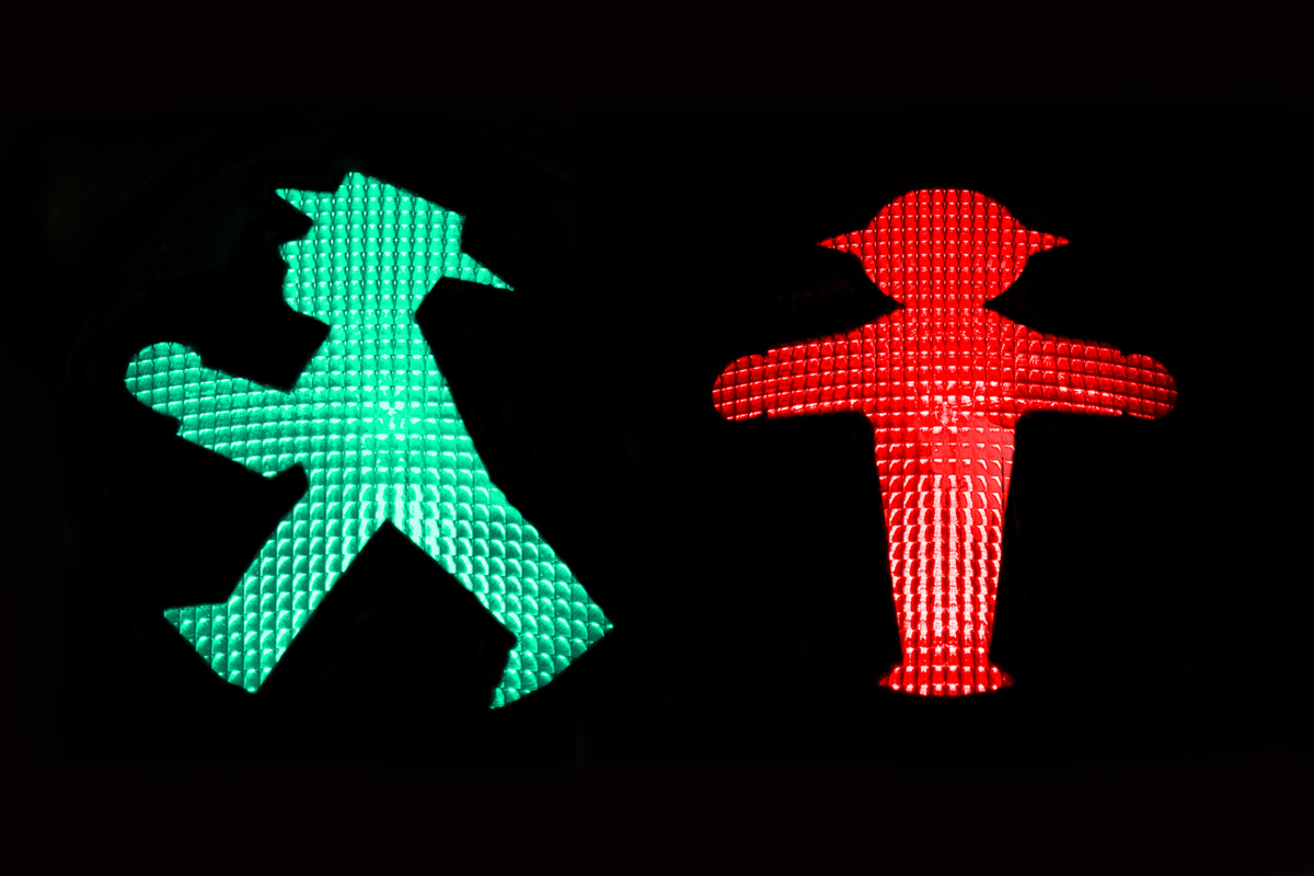 Green and red traffic light men on a black background