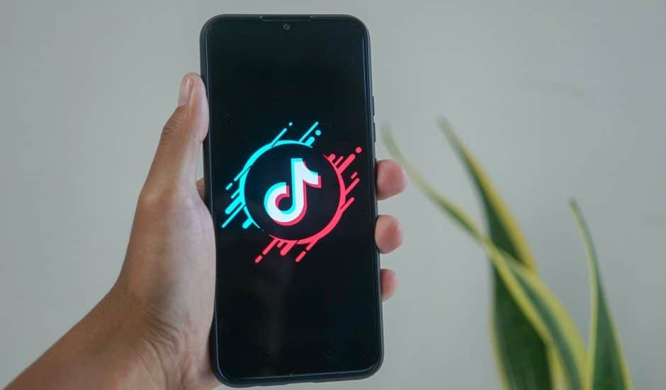 Une personne tient un smartphone avec l'application TikTok.