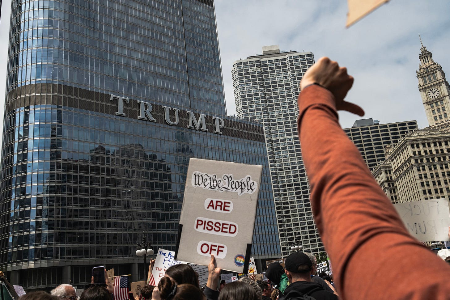 A protester gives a thumbs down gesture while marching past the Trump International Hotel and Tower in Chicago.