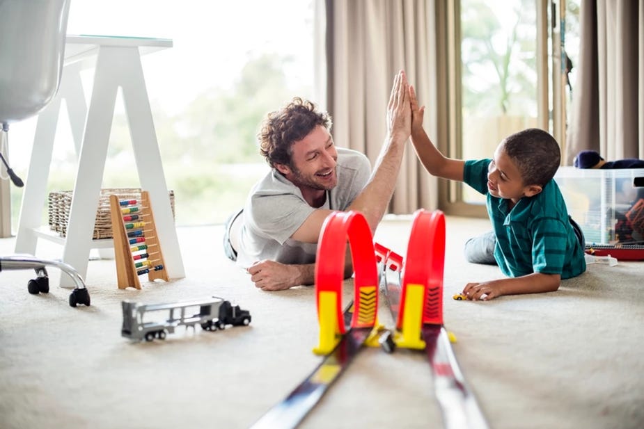 Picture of dad and son building a train and high-fiving