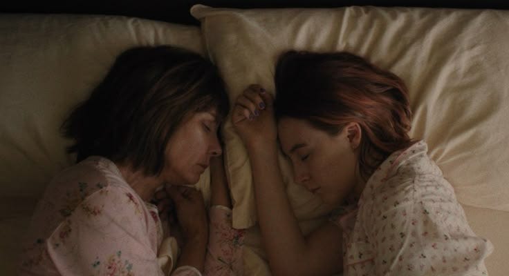 This may contain: two women are laying in bed together and one is holding her head against the pillow This may contain: two women are laying in bed together and one is holding her head against the pillow