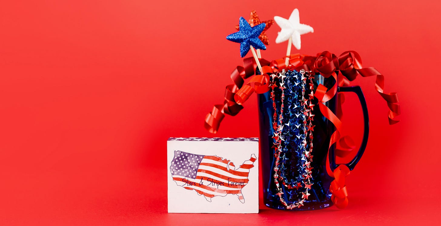 A gift package with red and blue streamers and decor to celebrate America 250 celebrations and July 4th / July Fourth. A placard of the USA is also present.