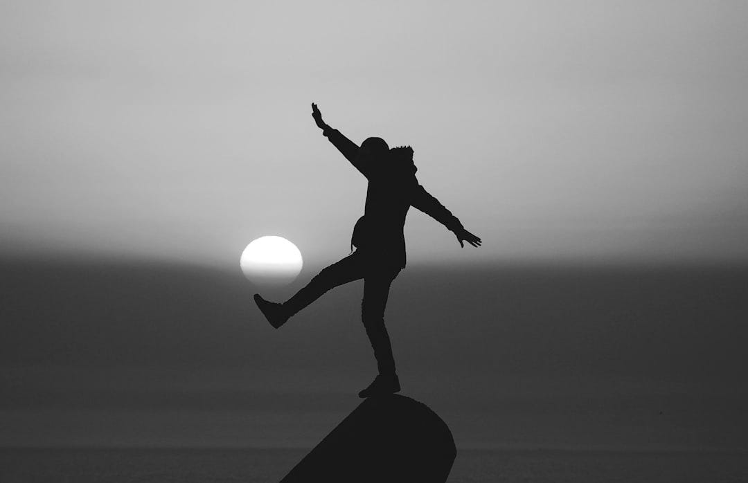 photo of silhouette photo of man standing on rock photo of silhouette photo of man standing on rock