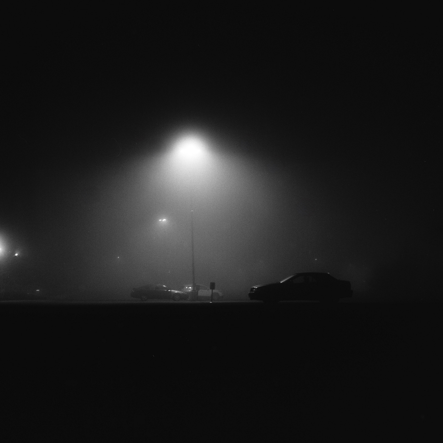Cars in a foggy parking lot