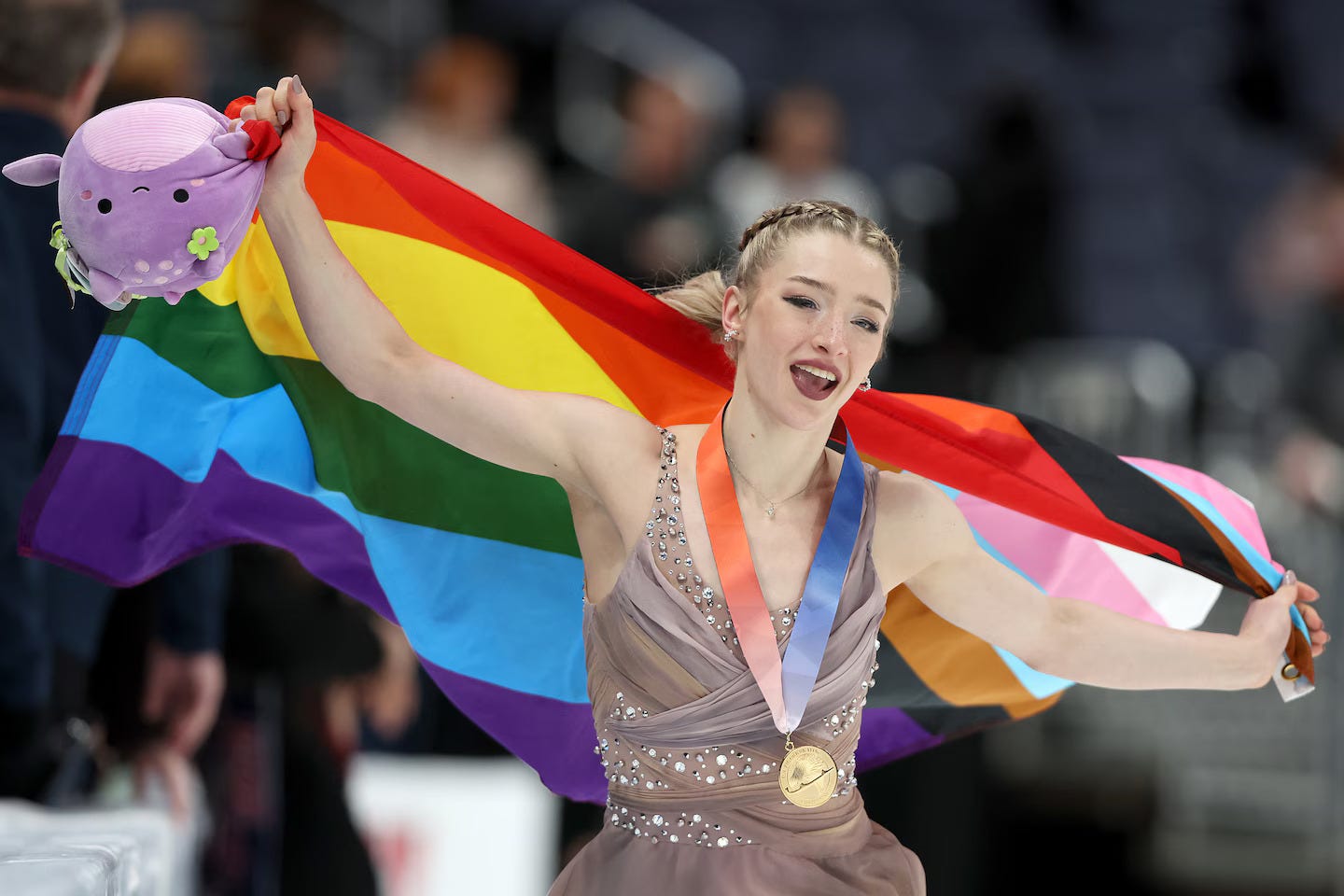 Amber Glenn holds a pride flag while wearing the gold medal for the US Championships