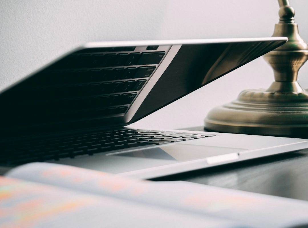 silver laptop computer near brown table lamp