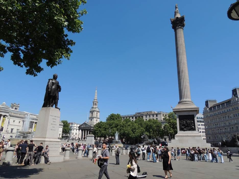 A group of people walking around a plaza with statues

AI-generated content may be incorrect.