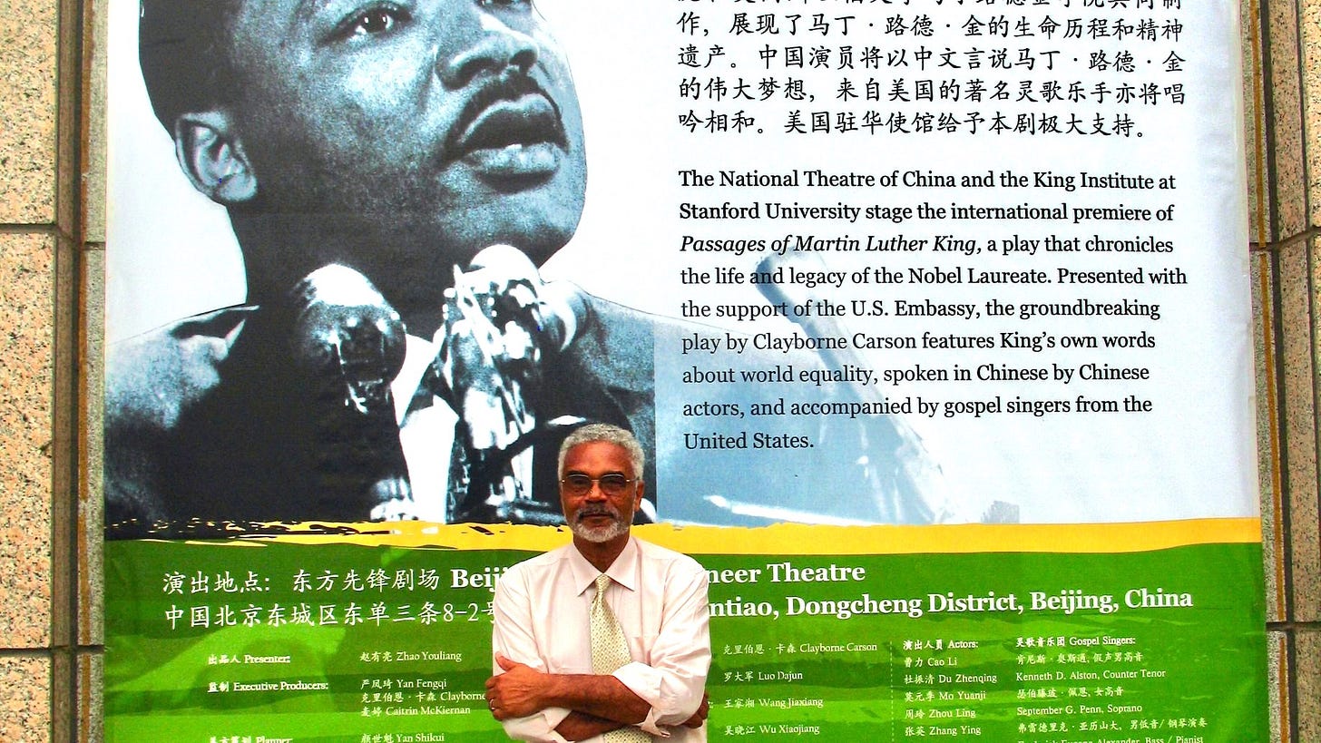 Dr Carson standing in front of the very large billboard advertising his play "Passages of Martin Luther King" in Beijing China.