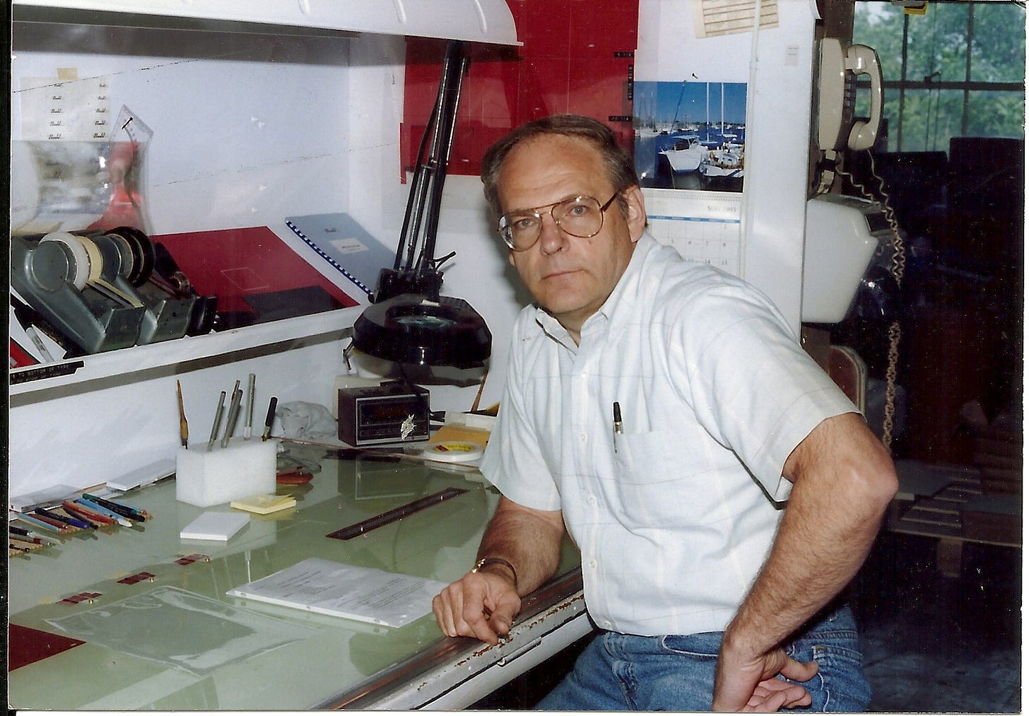 1980s era man sitting in front of a drafting table at work 1980s era man sitting in front of a drafting table at work