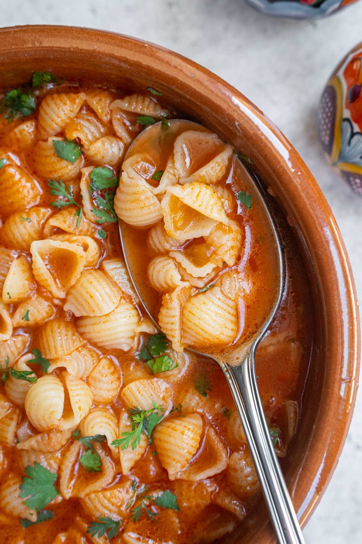 Eating sopa de conchas with spoon