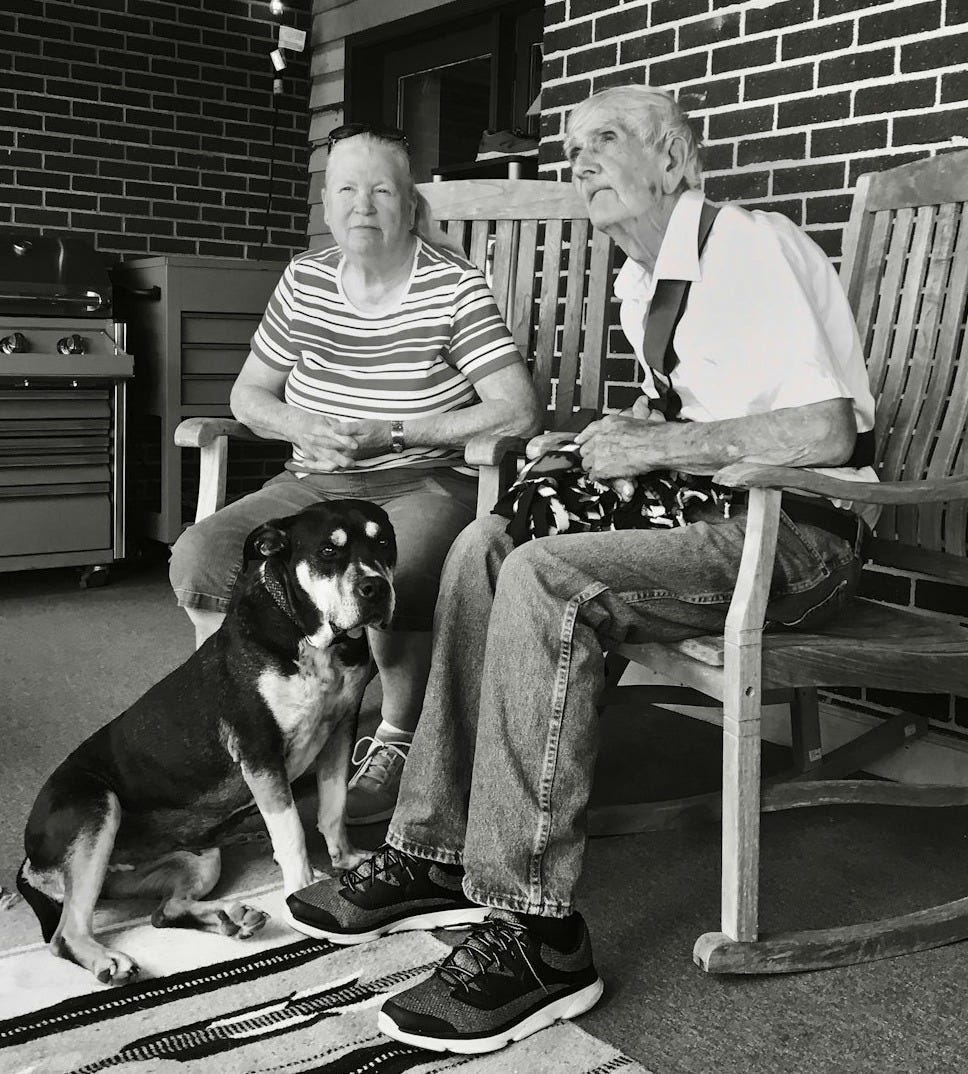 grayscale of man and woman sitting on wooden rocking chairs grayscale of man and woman sitting on wooden rocking chairs