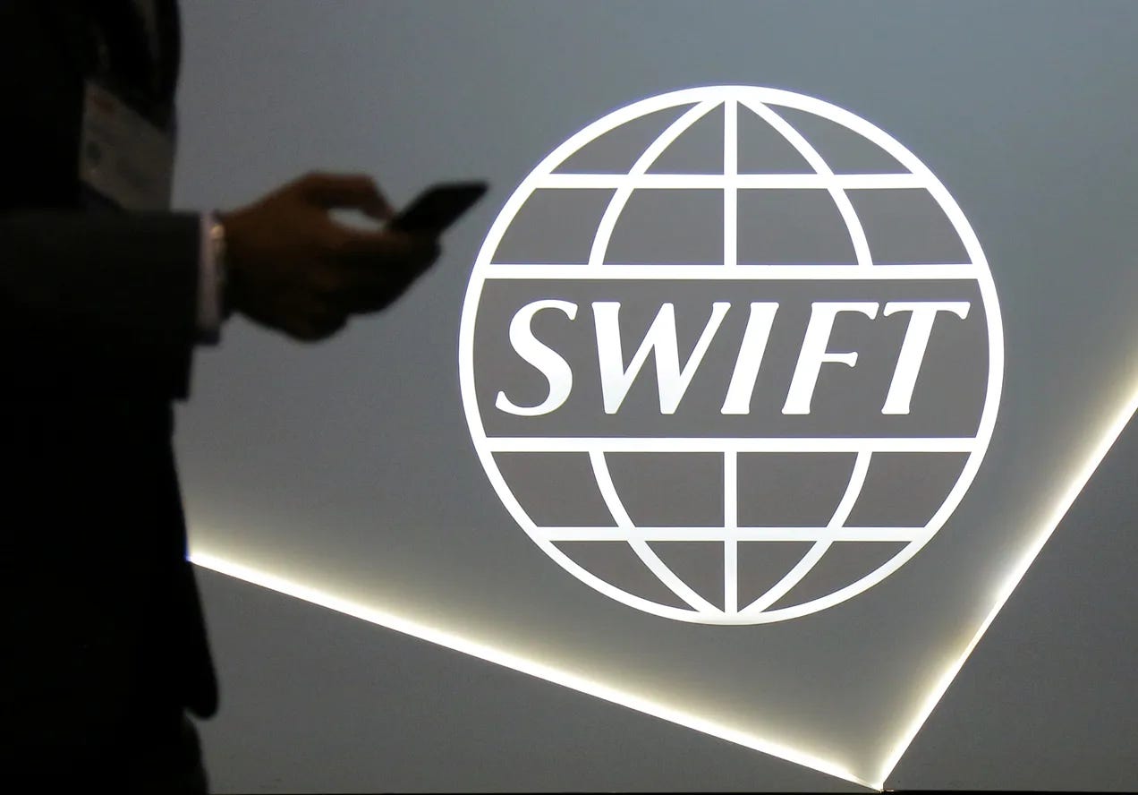 A man using a mobile phone passes the logo of global secure financial messaging services cooperative SWIFT at the SIBOS banking and financial conference in Toronto A man using a mobile phone passes the logo of global secure financial messaging services cooperative SWIFT at the SIBOS banking and financial conference in Toronto