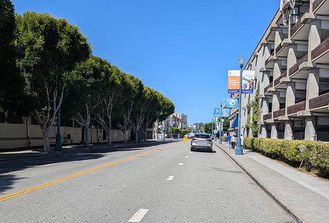 1: Wide street with a large parking garage, 2: Wide 4 lane Beach Street. Multi-level parking  garage on the right, 3: A zoomed photo of the street showing 5 parking signs.