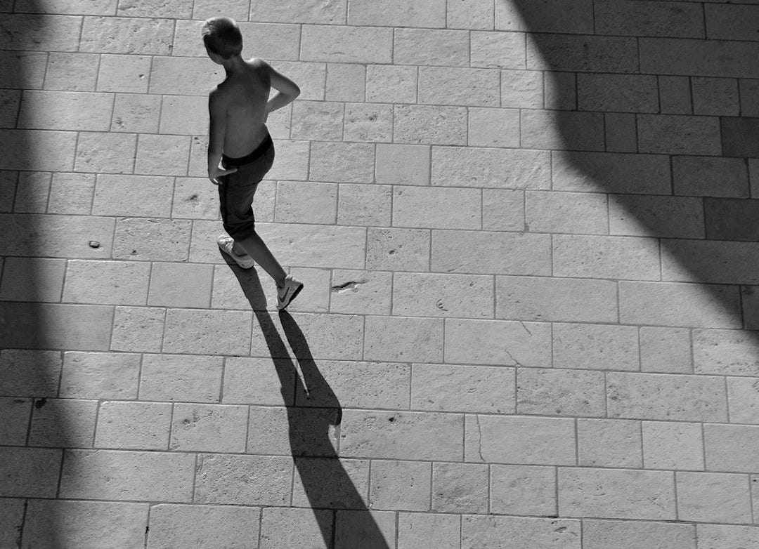 topless man walking on pavement