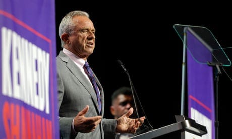 a man in a suit and tie speaks into a microphone