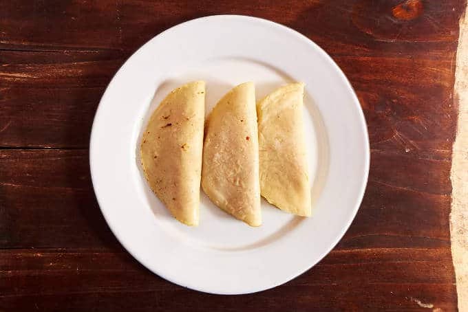 3 enchiladas on plate ready for sauce