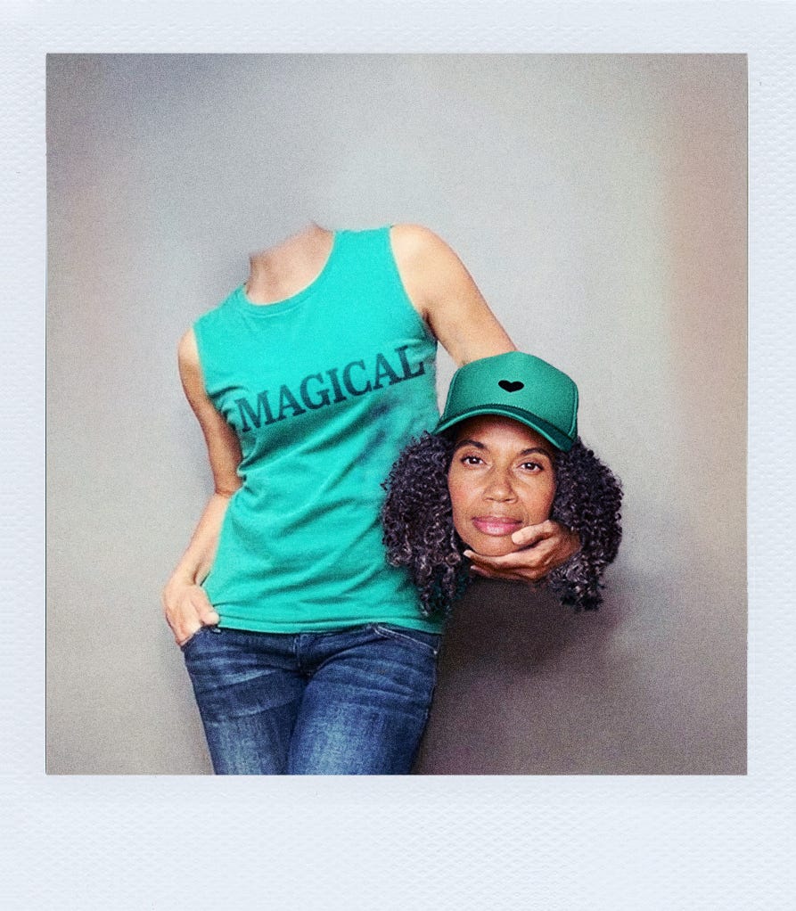 Woman in a 'Magical' t-shirt holding her head as a reminder to drop down into her body for guidance.