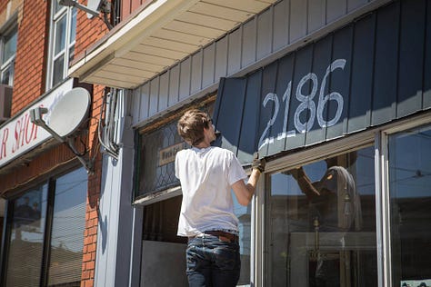 revealing the old hand painted sign at Black Cat Artspace