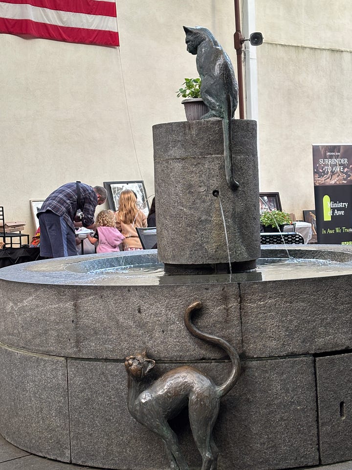 sculpture of cats playing in a fountain