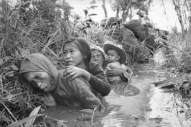 AP Vietnam: Women and children crouch in a muddy canal AP Vietnam: Women and children crouch in a muddy canal