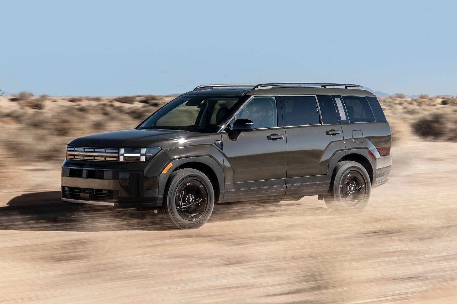 A 2024 Hyundai Santa Fe XRT driving in a desert on a sunny day.