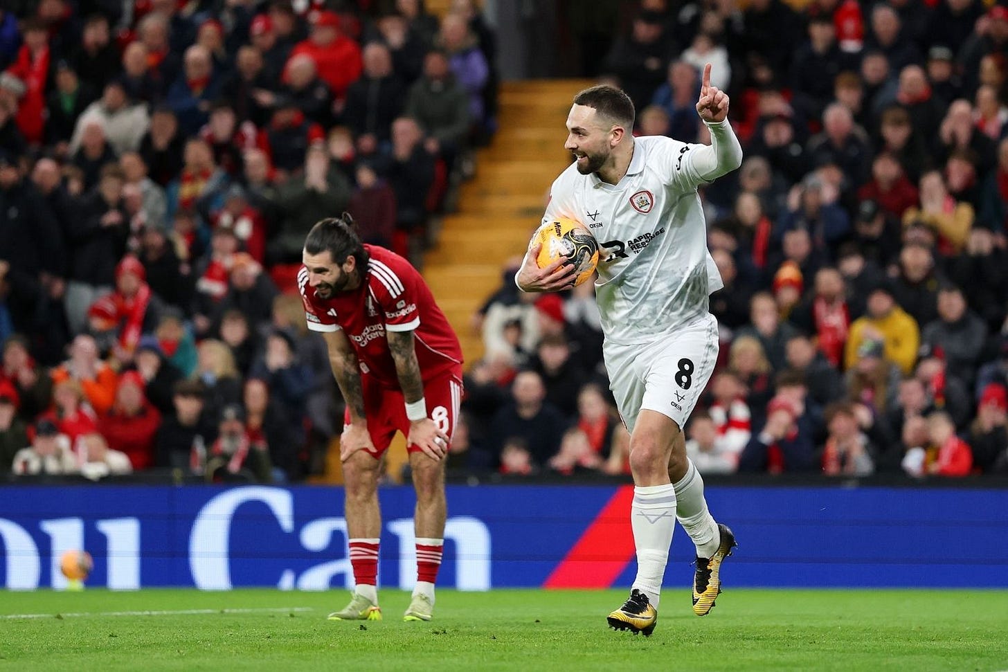Adam Phillips of Barnsley celebrates scoring his team's second goal as Dominik Szoboszlai of Liverpool reacts after making a defensive error