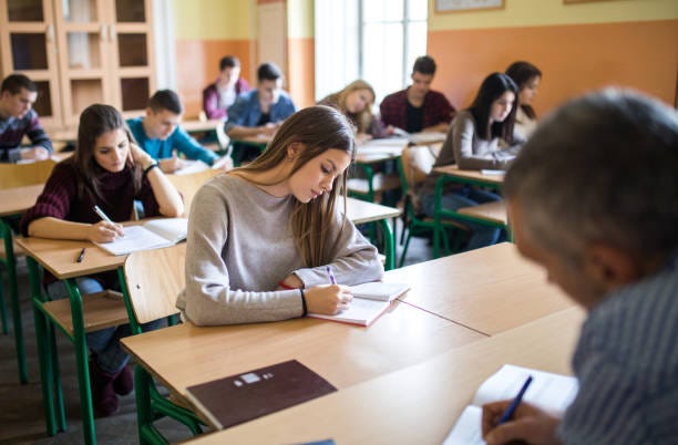 Group of high school students writing a test in the classroom.
