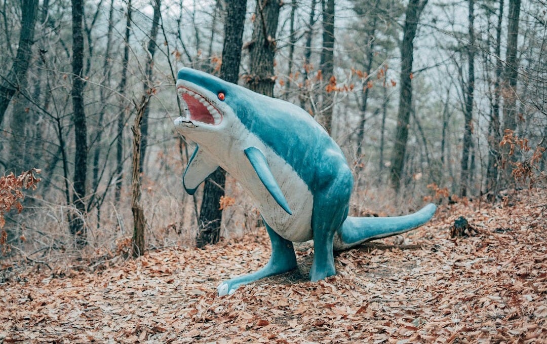 blue and white shark figurine on brown dried leaves