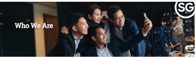 4 jeunes cadres dynamiques (3 hommes et une femme) singapouriens prennent un selfie en souriant. 4 jeunes cadres dynamiques (3 hommes et une femme) singapouriens prennent un selfie en souriant.