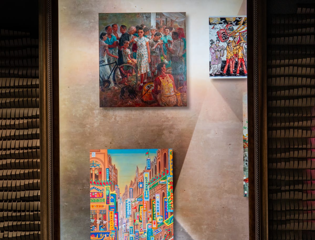 Paintings of a stylish woman in an open-air market and a colorful street scene are projected on a high-def digital display