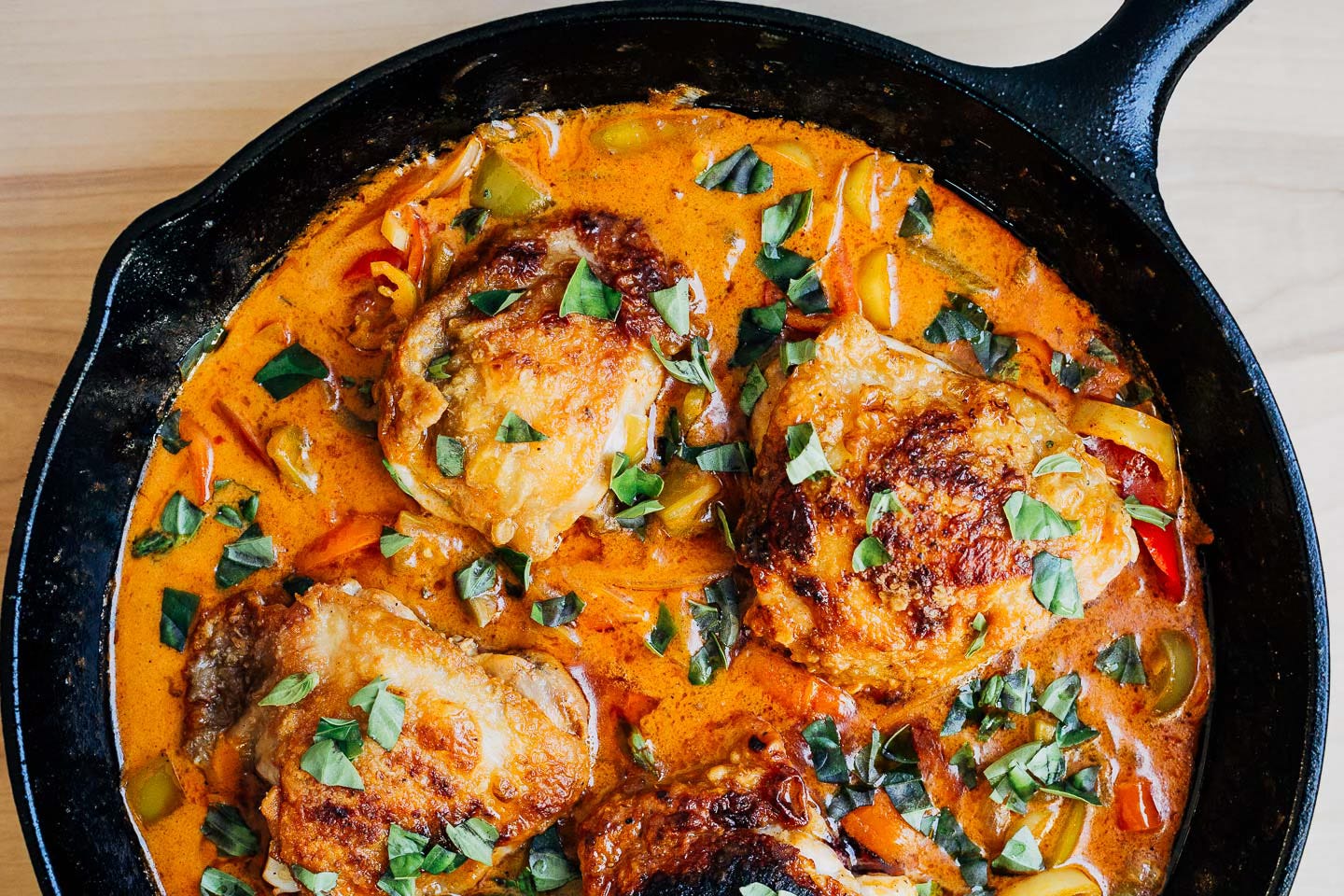 A cast iron skillet with coconut milk braised chicken