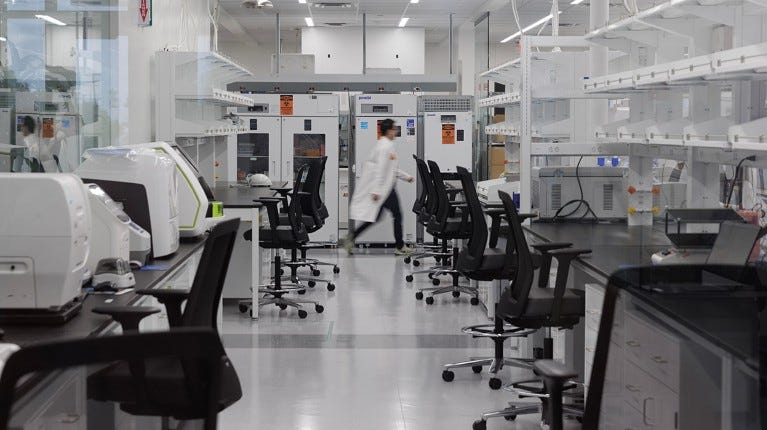 A researcher in a lab coat walks out of an empty laboratory in Dallas, Texas.