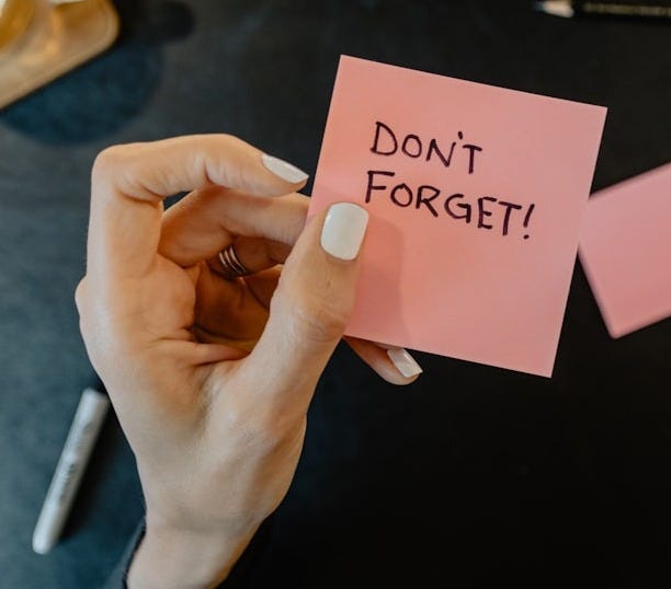 a person holding a note that says don't forget a person holding a note that says don't forget