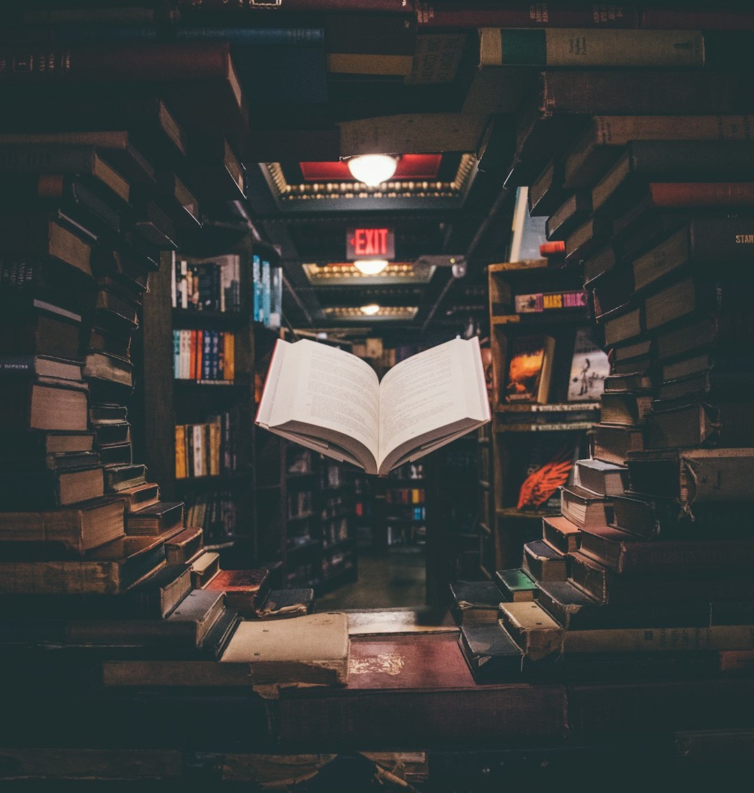view of floating open book from stacked books in library