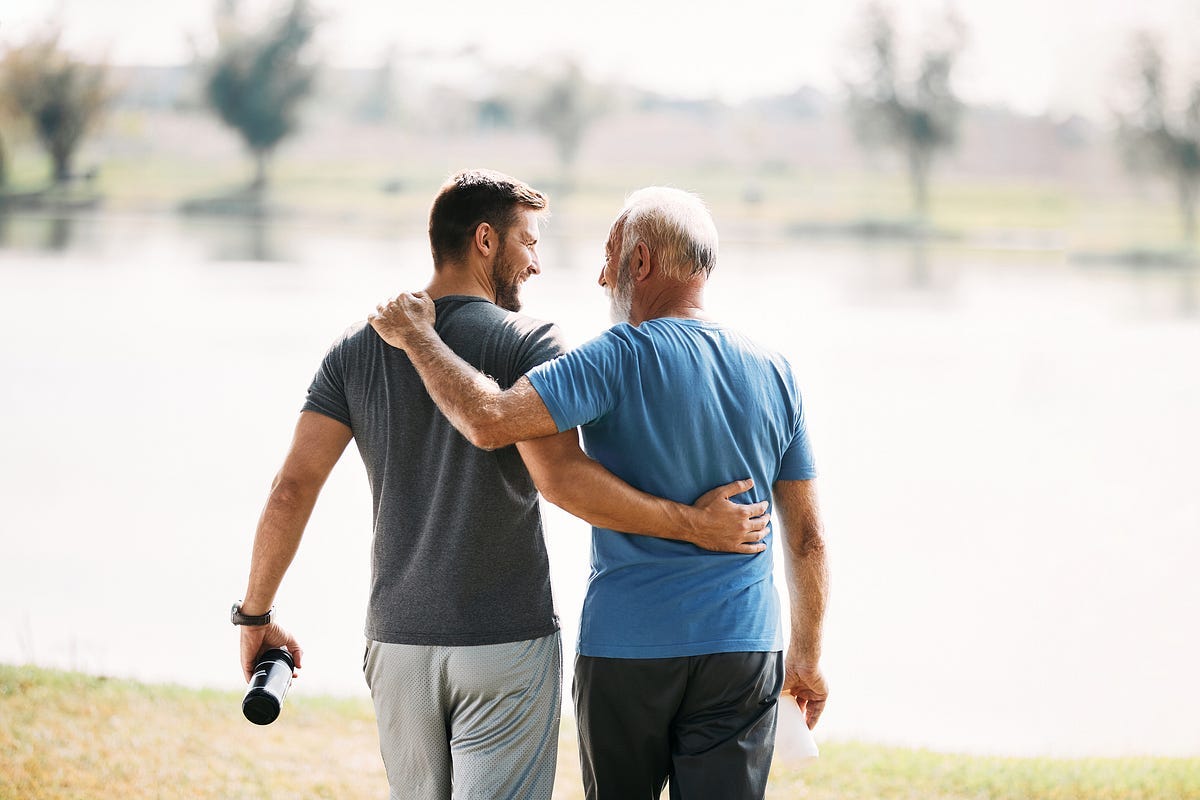 Photo of a father and son walking arm in arm.