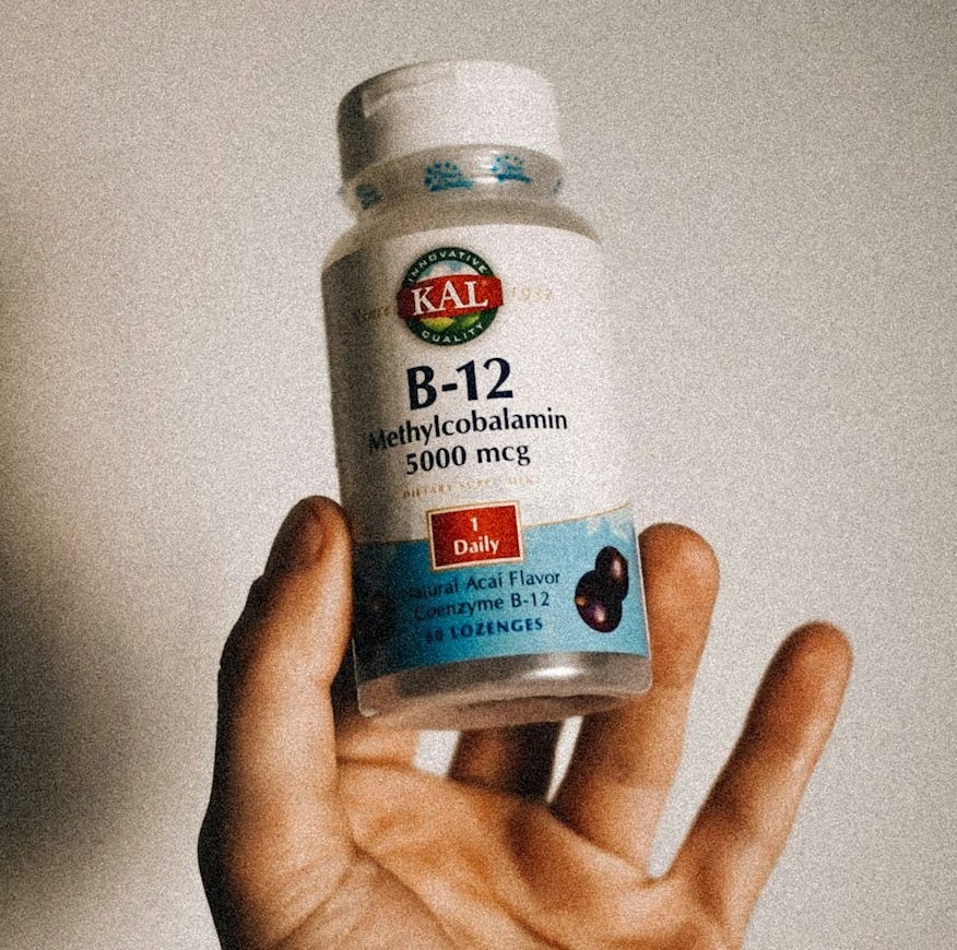 a person holding a bottle of vitamins in their hand