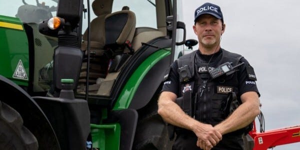 Officer next to a tractor