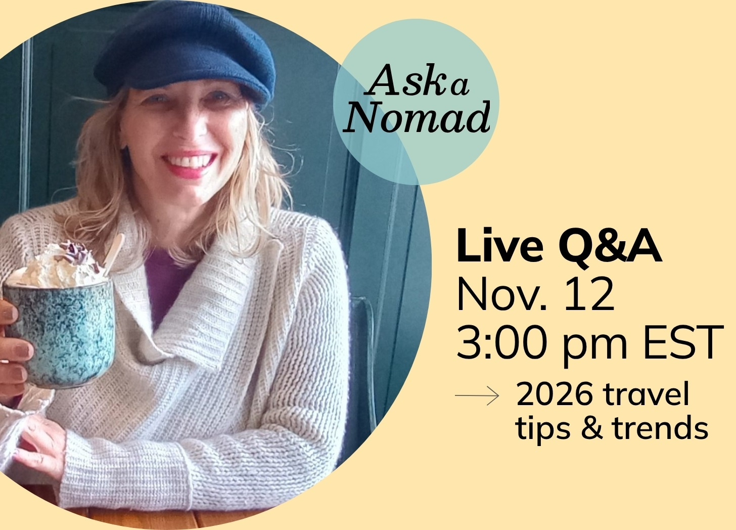 White woman with blond hair is wearing a big sweater and navy cap. She is smiling and lifting a cup of cocoa in a "cheers" gesture.