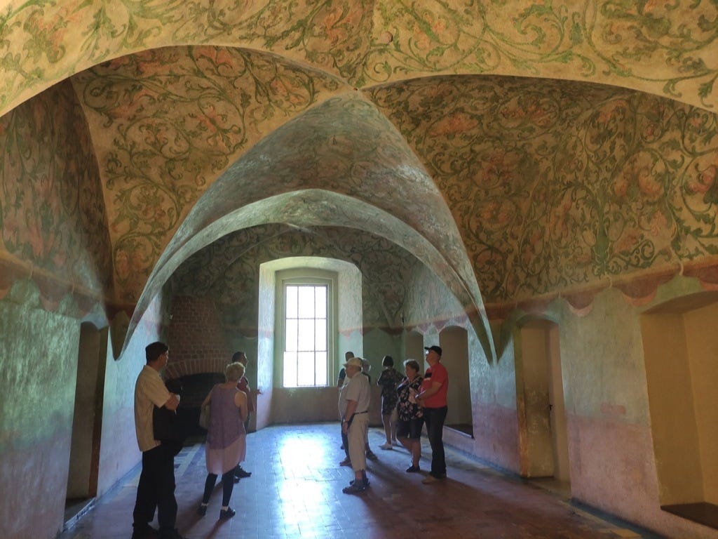 Curved arches on the ceiling, painted with creeping vines and flowers.