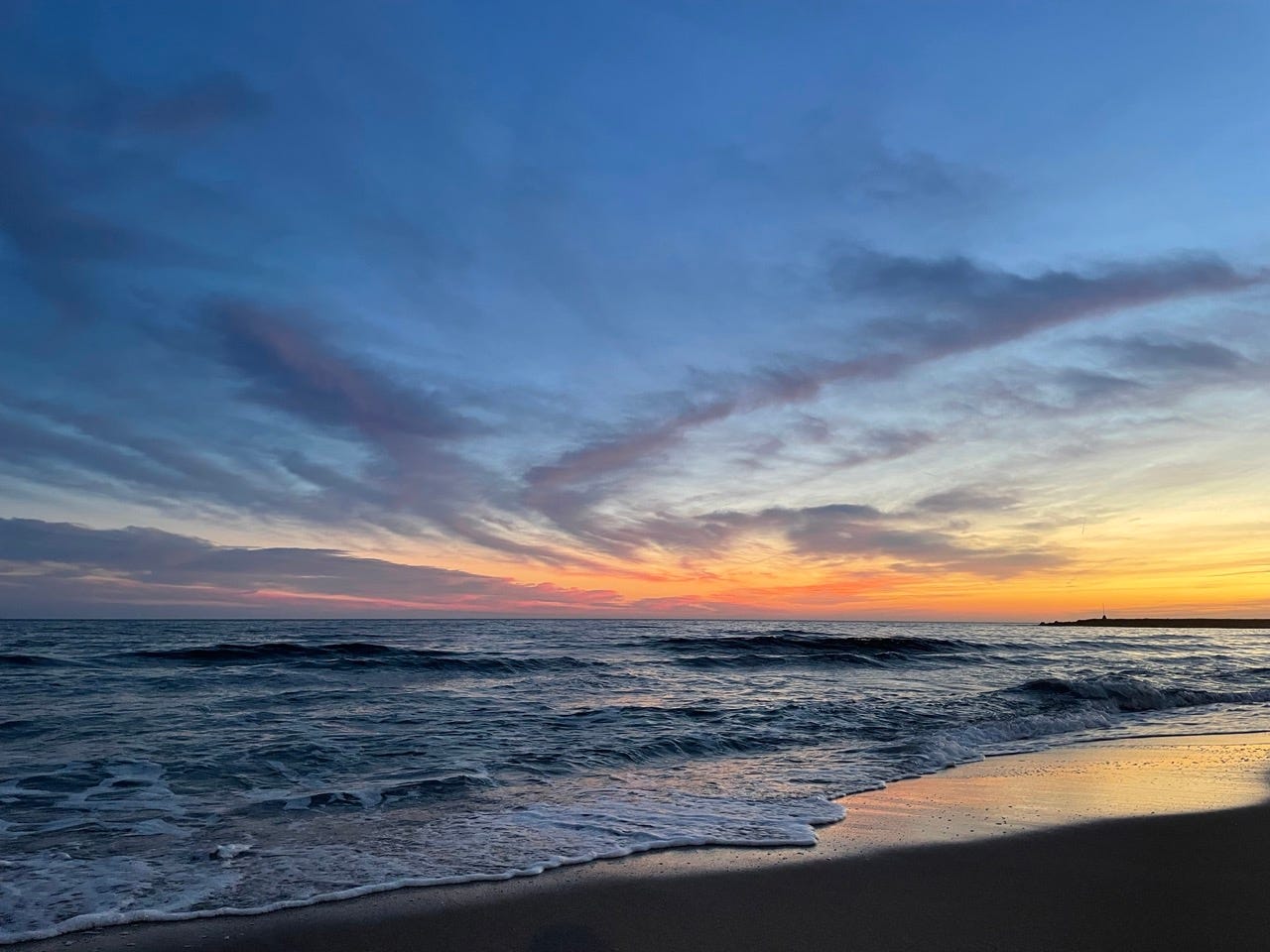 The sea and a sandy beach at sunset