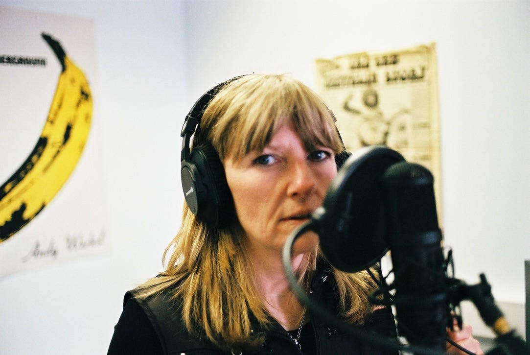 Woman with headphones singing into a microphone with pop shield Woman with headphones singing into a microphone with pop shield