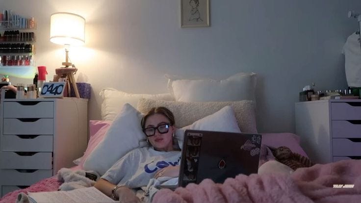 This may contain: a woman laying in bed with a laptop computer on her chest and reading books next to her