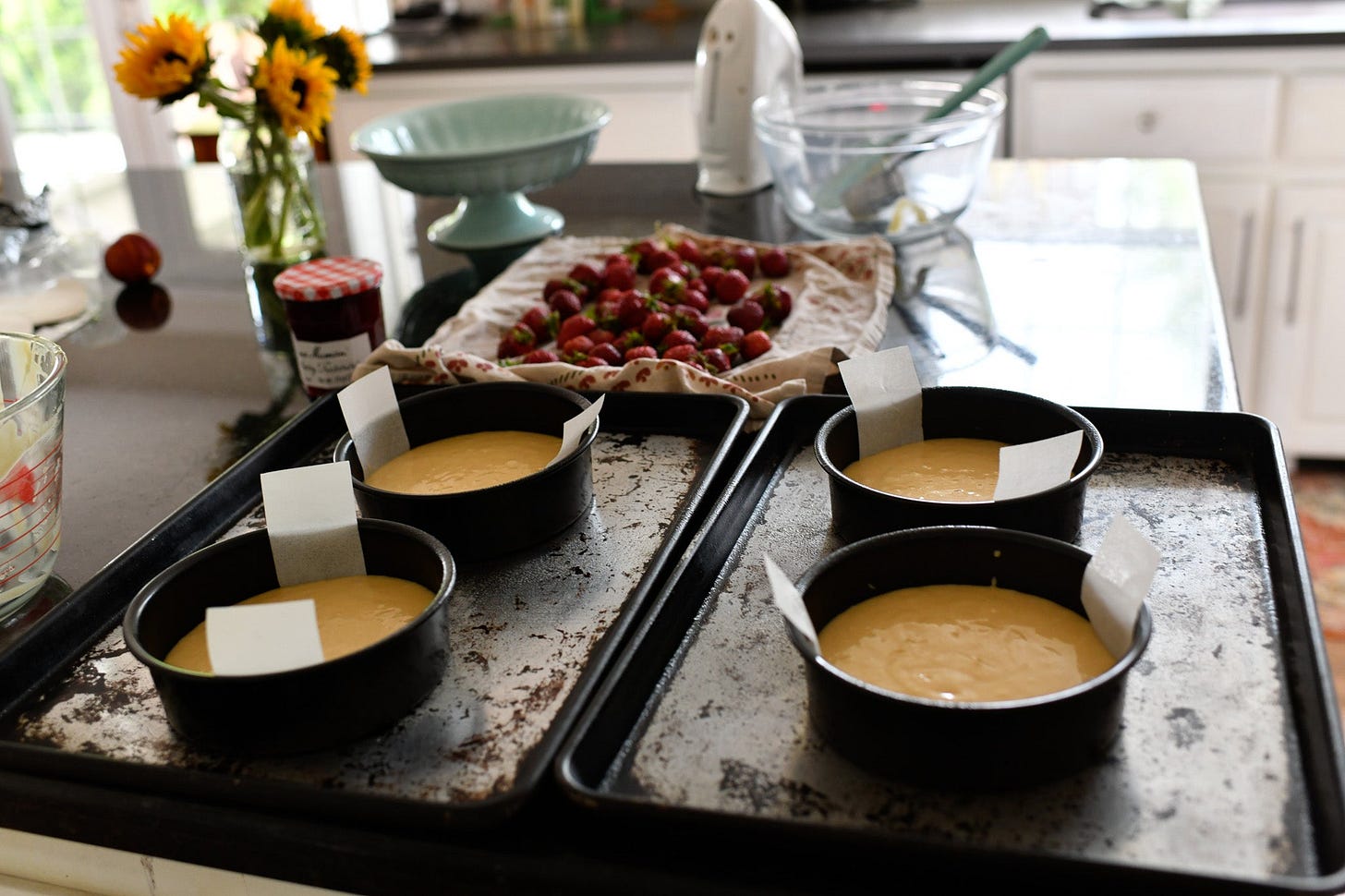 countertop scene making vanilla cakes with strawberries